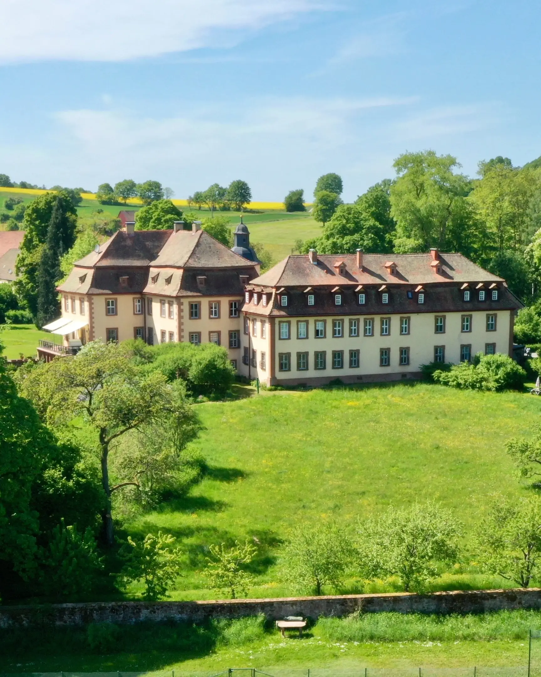 Luftaufnahme von Schloss Roßbach inmitten von Wiesen und Wald