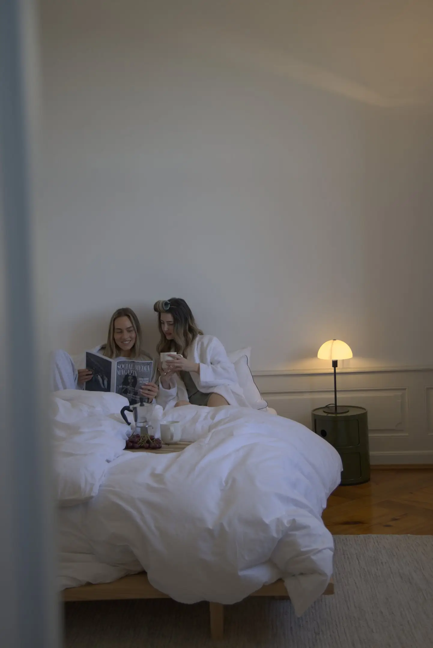 Zwei Frauen lesen im Bett eines ruhigen Schlafzimmers