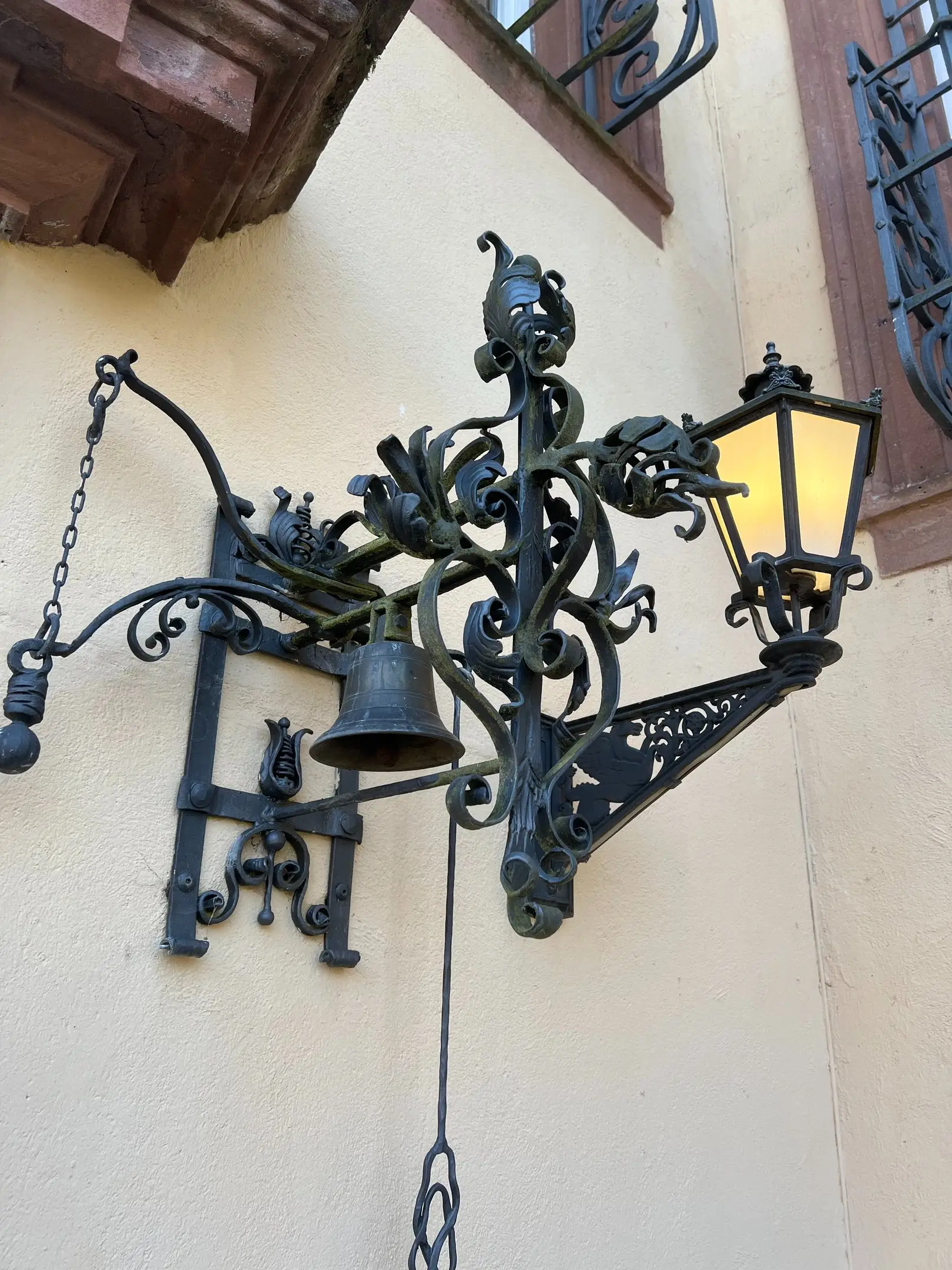 Schmiedeeiserne Wandlaterne mit Glocke an der Schlossfassade